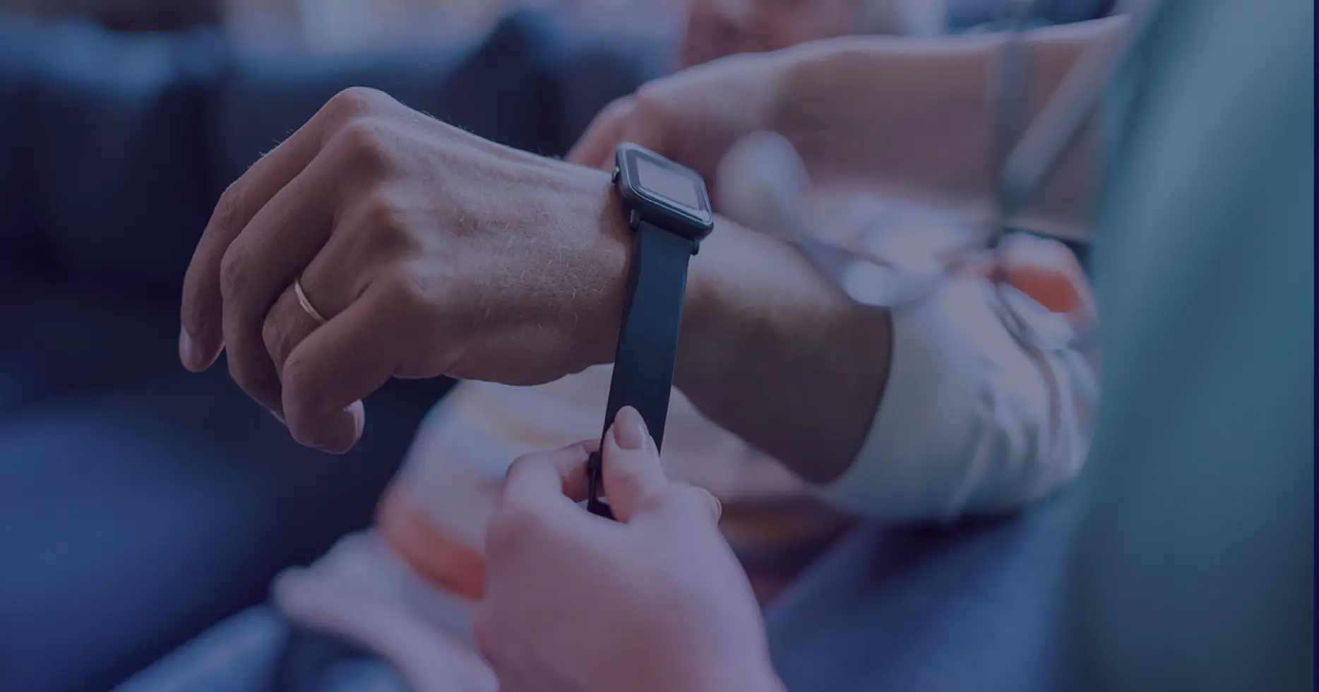 Close-up of a person adjusting a smartwatch, representing wearable IoT devices used in clinical data collection.